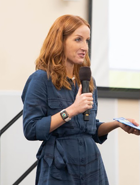 Vanessa Errecarte holding a microphone and speaking in front of a class of graduate students at UC Davis